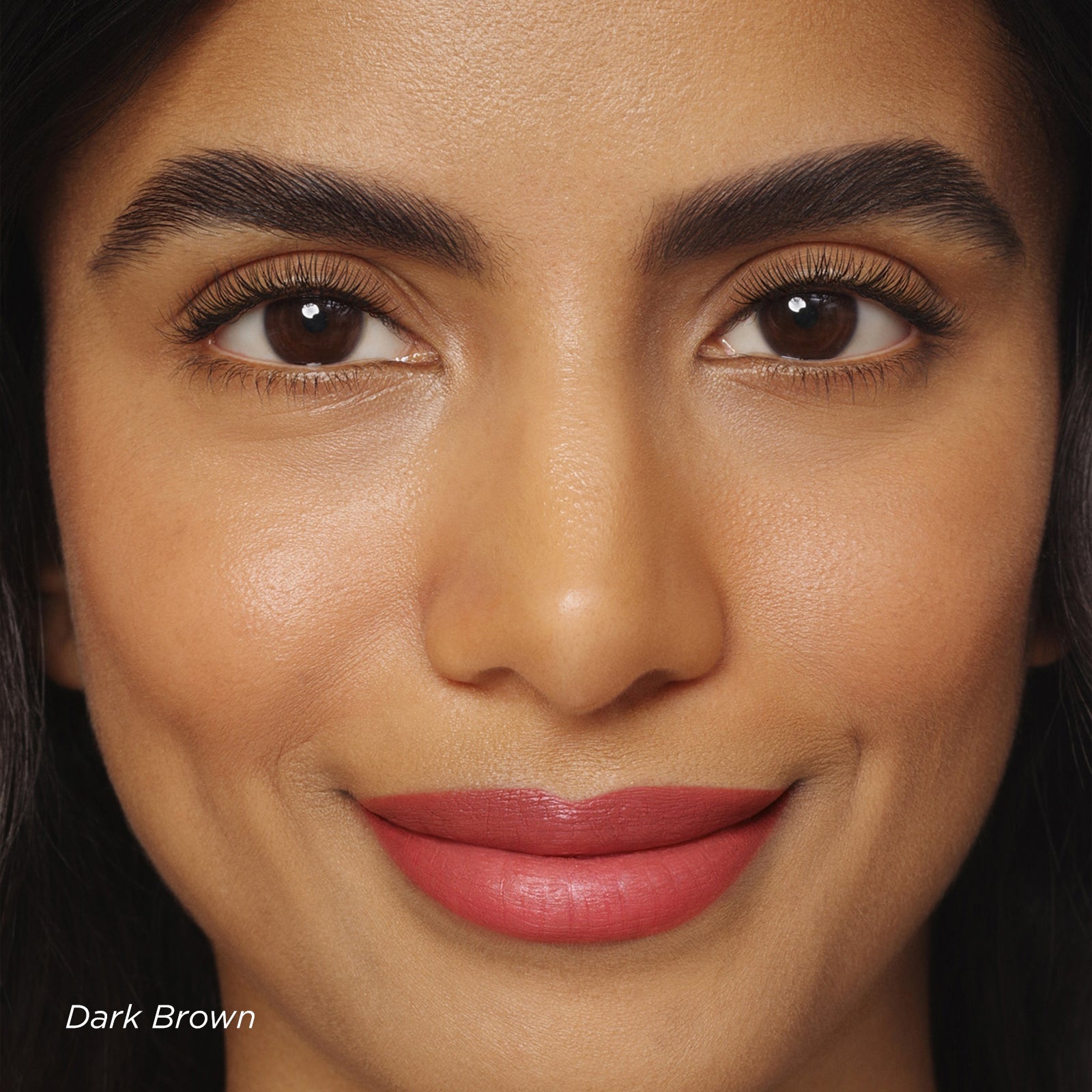 Close-up of a woman's face with dark brown eyes and red lipstick.