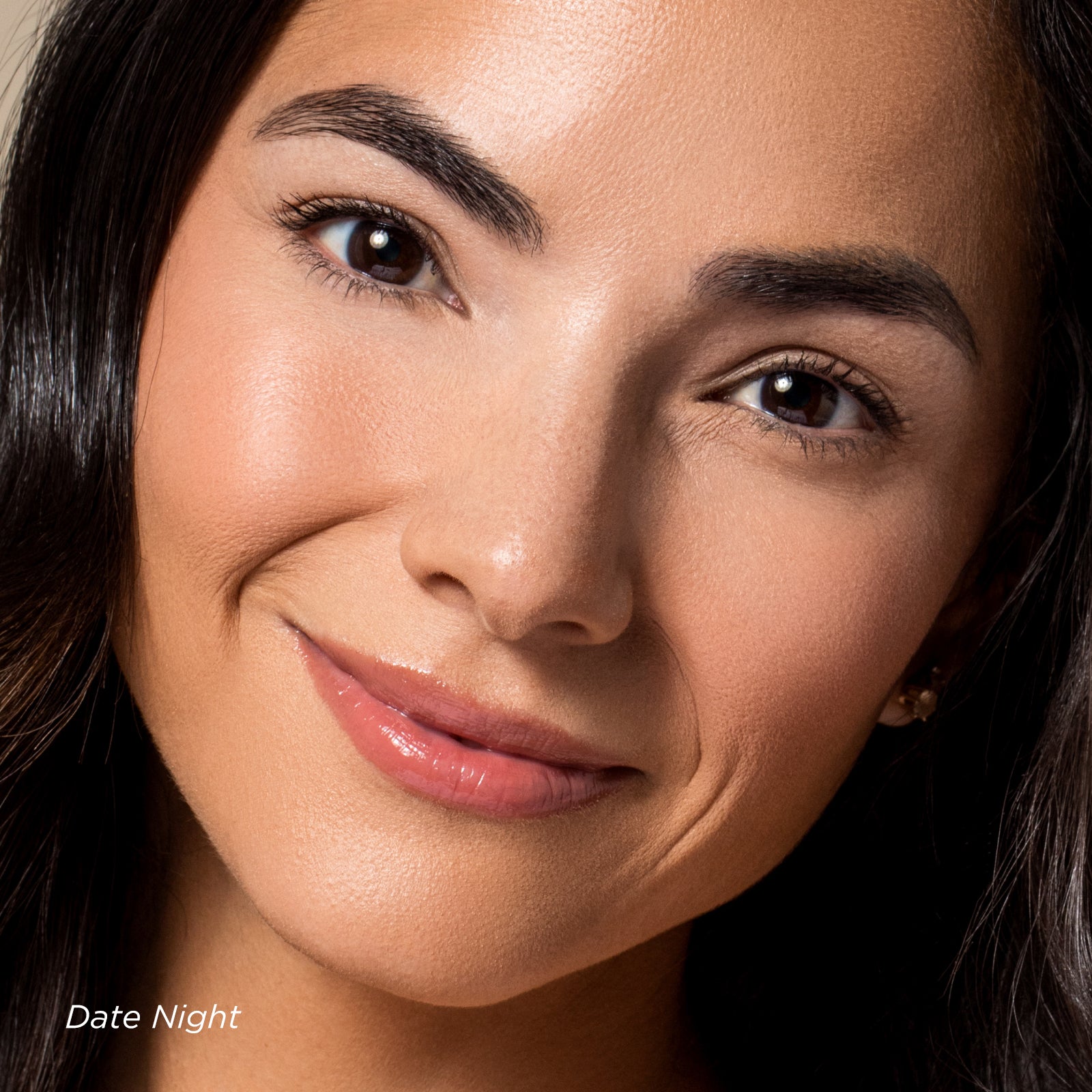 Close-up of a woman's face with a soft smile, wearing pink lipstick.